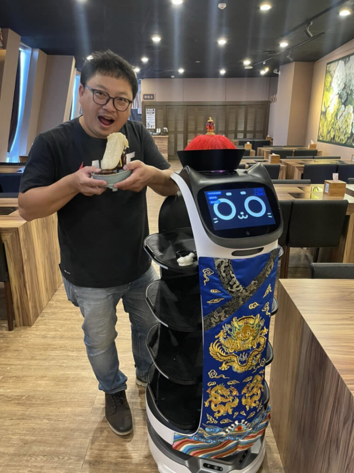 因應COVID-19（2019冠狀病毒疾病）疫情再起，國立故宮博物院南部院區鍋物餐廳加強防疫，引進AI機器人加入送餐行列，並為機器人客製一套刺繡太監服。（吳品諭提供）