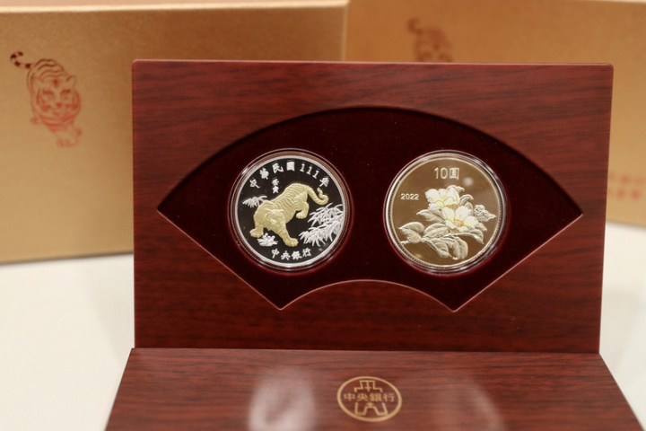中央銀行委請台灣銀行公開發售的「壬寅虎年生肖紀念套幣」採銀幣（面額新台幣100圓）及銅合金幣（面額新台幣10圓）各一枚組合成套，銀幣正面以局部鍍金的「虎」圖樣為主題，銅合金幣背面則為部分上彩的「山茶花」，具有高潔、謙讓的寓意。