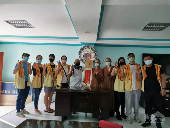 妙淨法師〈右5〉贈送星雲大師墨寶「花開四季，耕耘心田」予副市長威廉〈左5〉