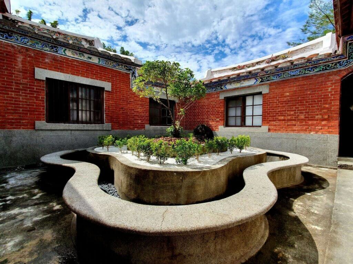 屏東市區保存最完整的客家歷史建築「邱姓河南堂忠實第」歷經1年多的時程，終於完工，18日亮相。建築外觀鮮明紅瓦搭配樸實的洗石子墻，梁柱間精雕細琢的木構件、交趾陶墻飾與屋脊剪粘，為向來樸實的傳統客家建築增添華麗的裝飾風格。（屏東縣政府提供）