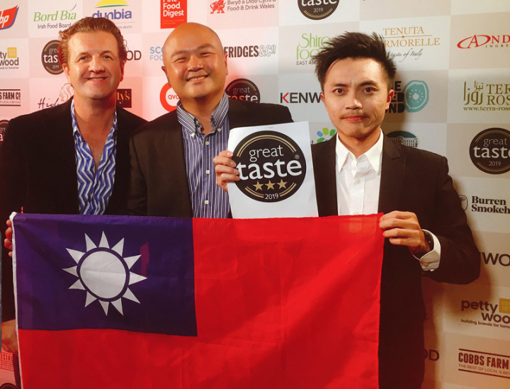 製茶職人張家齊（右）2019年起連3年在英國Great Taste Awards獲獎，上台領獎時不忘展開中華民國國旗，讓世界看見台灣。（張家齊提供）