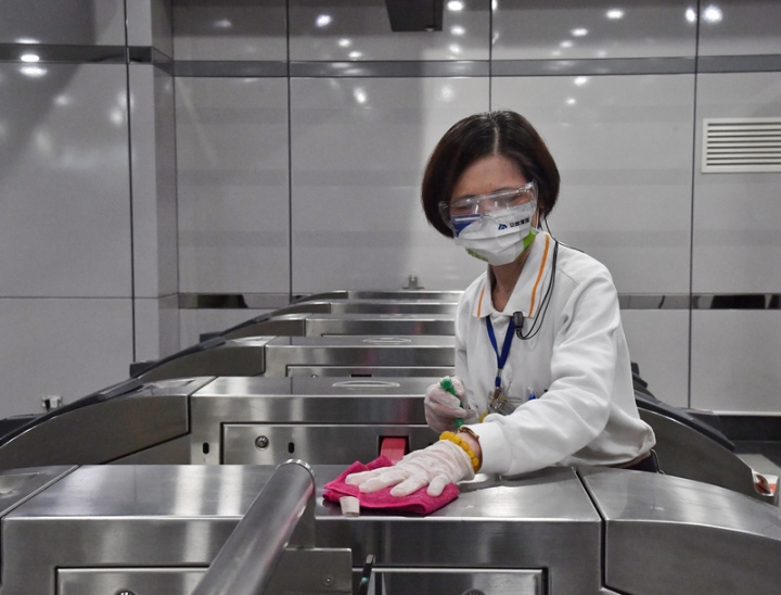 台灣高鐵為落實防疫，打造安心乘車環境，除加強各車站清消，也針對列車組員進行個人防護裝備訓練課程，23日首度對外公開。圖為高鐵清潔人員消毒驗票閘門。