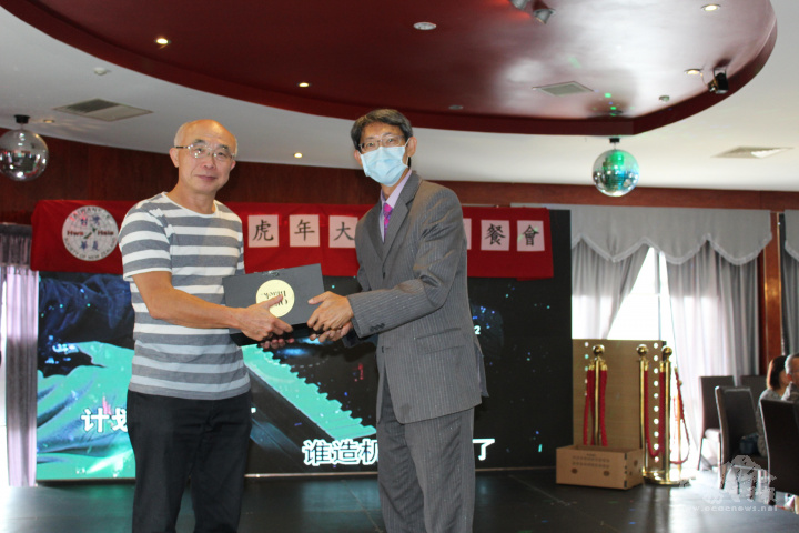 尹文新（右）與幸運的獲獎僑胞合影