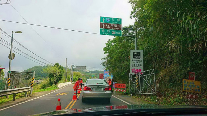 阿里山花季登場，12日首個週末假日湧入大批人潮賞花，嘉義縣警方在台18線阿里山公路進行交管，上午限制小客車上山，駕駛需把車停放61K樂野服務區停車場，再轉乘接駁車上山。（警方提供）