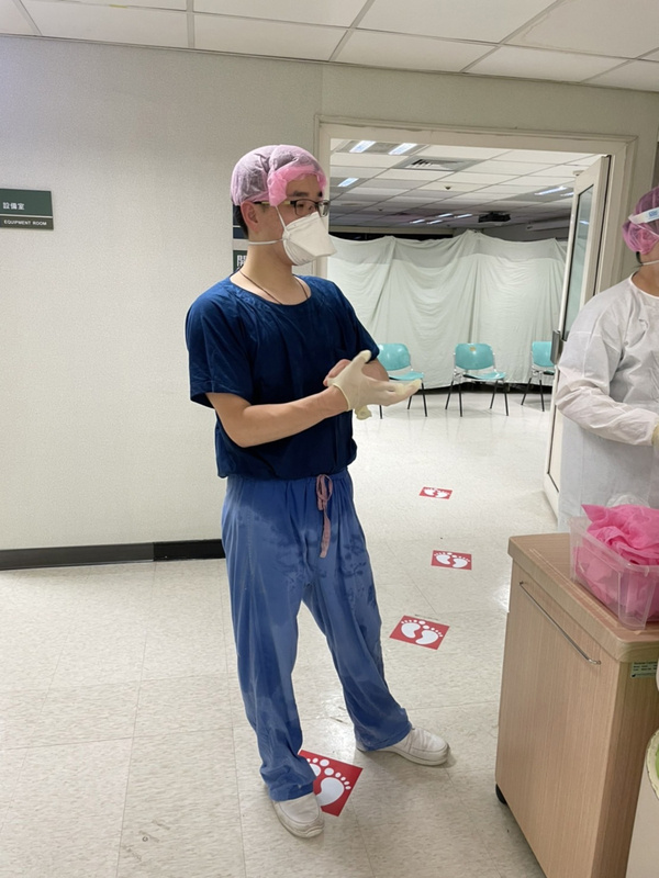 為了照顧COVID-19確診者，又要避免被傳染，林口長庚醫院護理團隊必須穿上密不透風的防護衣，兩兩一組進入隔離病室替患者打點滴、給藥、拍背，時常一忙就是4小時，脫下隔離衣，全身早已被汗水浸透。（范紀萱提供）