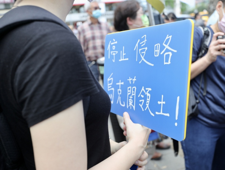 俄烏戰火延燒，一群台灣、烏克蘭、立陶宛、波蘭等 國人13日在台北發起「聲援烏克蘭和平大遊行」，參 與民眾手持標語，抗議俄羅斯入侵烏克蘭。