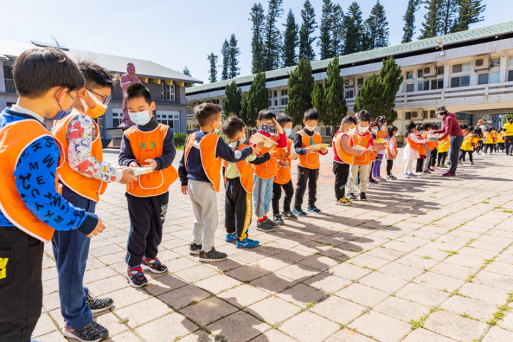 金門縣金湖國小附設幼兒園新設「戴勝書屋」，將於25日啟用，園方舉辦人龍搬書活動，300名師生排成200公尺人龍，將上千本書一本本傳遞下去。（金湖國小附設幼兒園提供）