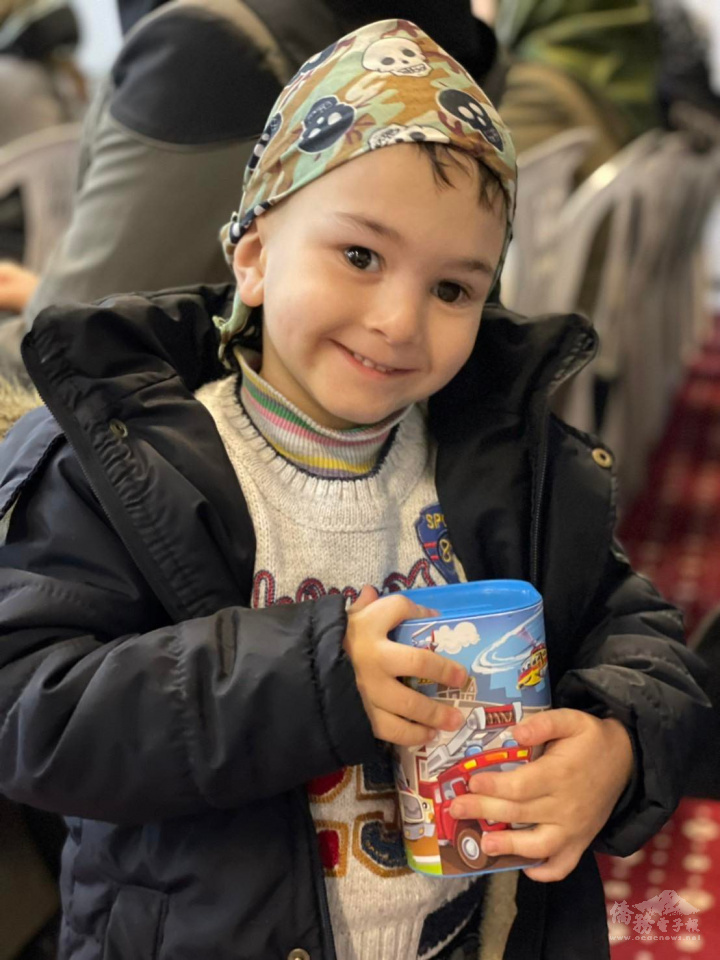 拿著存錢筒的孩子露出天真可愛的笑容，撫慰了人們的心