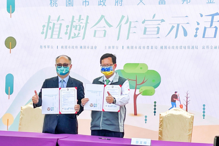 桃園市長鄭文燦（右）與富邦金控總經理韓蔚廷（左）代表簽署「濱海綠色廊道植樹合作備忘錄」，將沿台15線以西，以許厝港濕地為示範場域，栽種台灣原生濱海植物1萬6800棵，打造完整生態圈。
