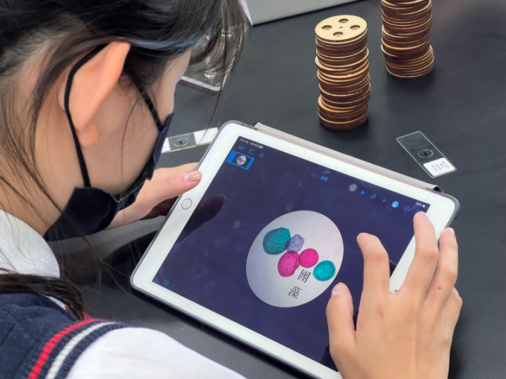 台中私立葳格中學規劃跨領域課程，讓學生使用數位式顯微鏡和iPad，拍攝生物或化學課程中介紹的生物細胞、常見化學反應，將顯微照片設計成融合科學與文學的作品。