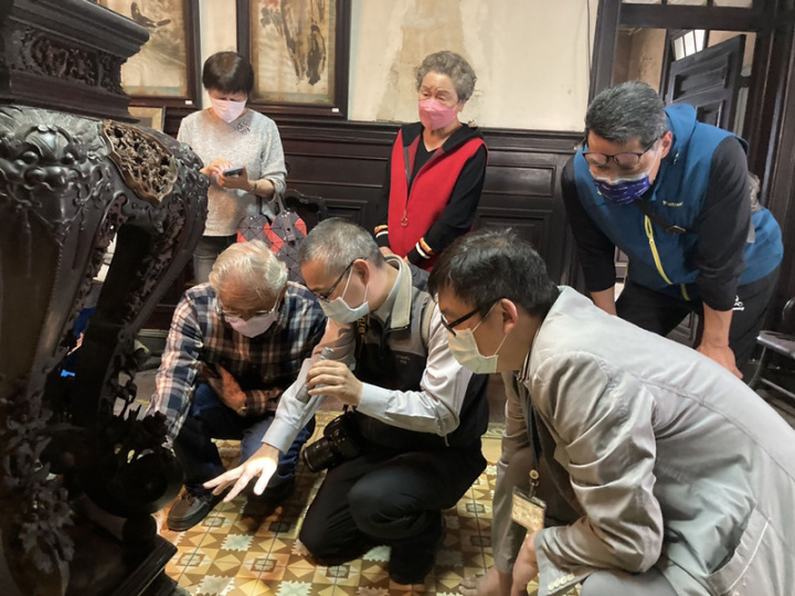 台北市定古蹟陳天來故居共盤點出261件書畫及木製家具等文物，7日邀藝師游禮海（前左）鑑賞一座雕刻精美、繁複的六角牡丹曲足鑲嵌人物高香几。