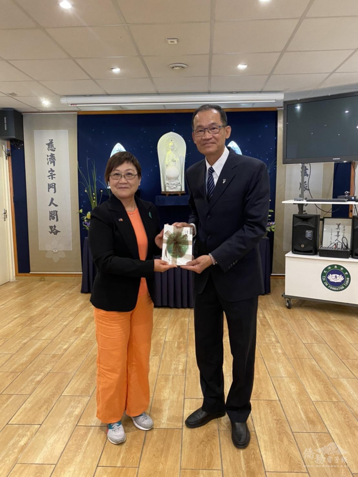黃行德僑務諮詢委員(右)代表慈濟基金會法國分會贈送紀念品予僑務委員會副委員長徐佳青(左)