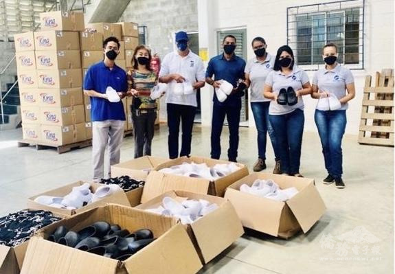 林幸昭（左二），兒子陳潔明（左一）贈送托鞋給弱勢族群及貧困家庭