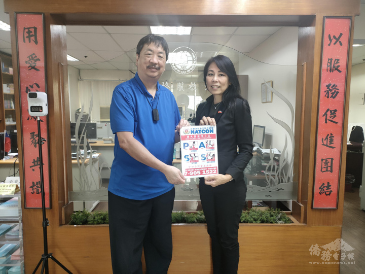 蔡懷強〈左〉將雙語使用滅火器P.A.S.S.步驟說明卡交予李欣芬〈右〉