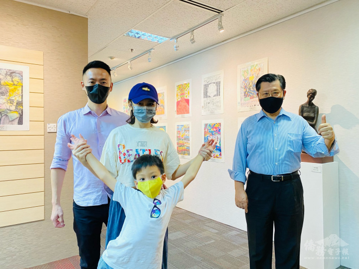 梁國新(右)與參觀駐新加坡代表處舉辦「世界兒童畫展」的僑胞合影