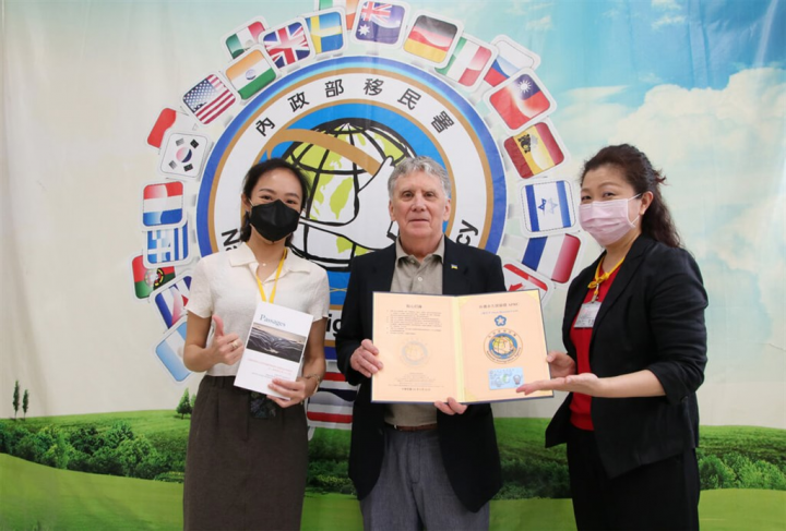 American poet George O'Connell (center) receives a Plum Blossom Card from the National Immigration Agency Tuesday. Photo courtesy of NIA