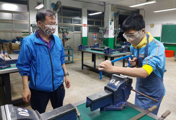 新北市泰山高中老師許恭維（左）指導崇林國中學生劉品佑（右）參加新北市國中技藝競賽機械職群鉗工基礎工作主題，勇奪第一，師生同獲教育部全國技藝教育績優人員肯定。（新北市教育局提供）