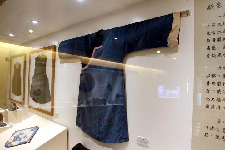 客家文化園區「見古說今－園區典藏文物展」將持續展出至6月15日，展區主題包含「客家女性的新生與成長」，展出女性傳統服飾、飾品及生活用品等，如色澤淺藍色、衣長及膝、開右襟的大襟衫（藍衫）。（新北市客家局提供）