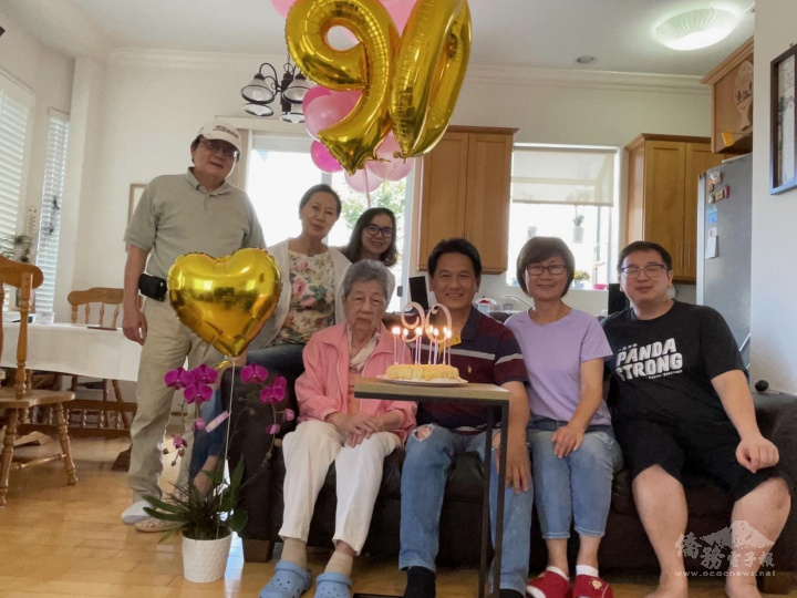 中間粉紅上衣白褲陳王玉華女士九十歲生日與家人合影