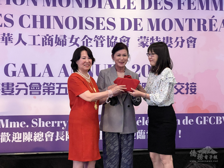 世華婦女會總會長陳阡蕙（中）在世華婦女會蒙特婁分會監交卸任會長高慧清（左）與新任會長蕭惠華（右）之印信交接