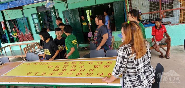 SHALOM孤兒院院童在布條上以簽名或畫圖的方式，感謝臺灣天目城集團總裁李姿慧的善心