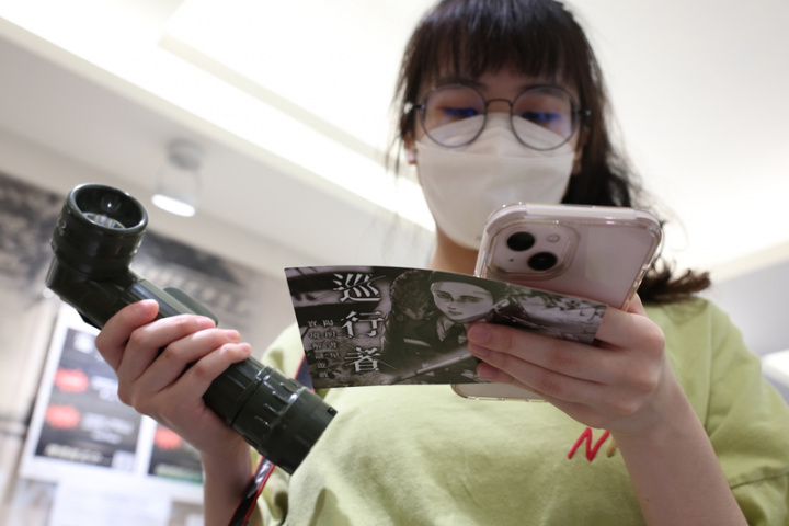 陽明書屋前身是中興賓館，書屋解說員們發想出「巡 行者」實境解謎遊戲，盼引領年輕玩家更了解當年歷 史。圖為參與者進入遊戲前，透過手機瞭解遊戲規 則，準備挑戰實境解題。