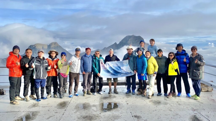 新台幣1000元鈔票背面有玉山圖案，駐台使節登山團在玉山舉了一張放大版的千元鈔票布條大合照。（圖取自twitter.com/Jordan_J_Reeves）