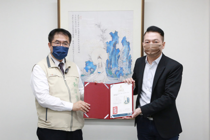 夏荊山文化藝術基金會執行長趙忠傑（右）18日前往台南市政府拜會台南市長黃偉哲（左），並共同揭開出借給市府的畫作。（台南市政府提供）