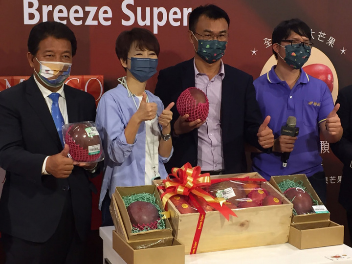 來自台南玉井的新品種芒果「大蘋果芒果」21日在台北信義區的超市舉辦拍賣活動，每顆重達1.5公斤，是一般芒果3倍大，外型紅又圓潤，農委會主委陳吉仲（右2）也為力挺國產農產現身會場。