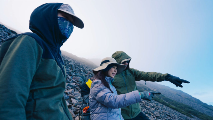 生態節目「地球的孤兒」主持人白心儀（中）與攝影夥伴攀登玉山，追尋有「黃色閃電」美譽的台灣保育動物黃喉貂身影。（東森提供）