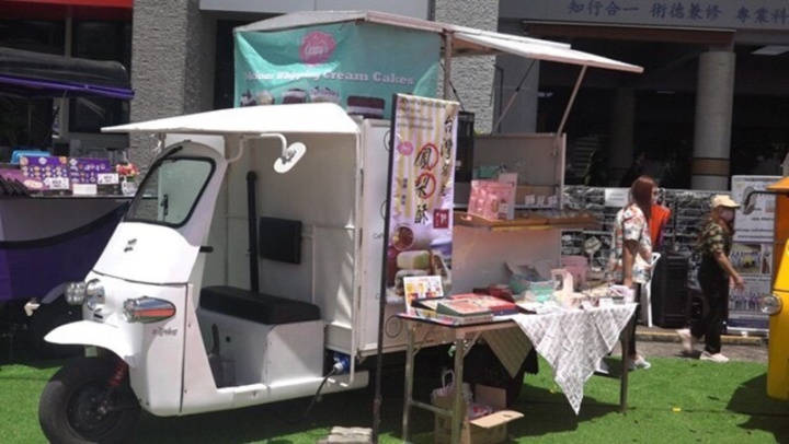 泰國－台灣BDI科技學院展示學生研發的電動嘟嘟車，能節省能源、降低空汙、提升載貨量。圖為正販售台灣鳳梨酥的電動嘟嘟車。