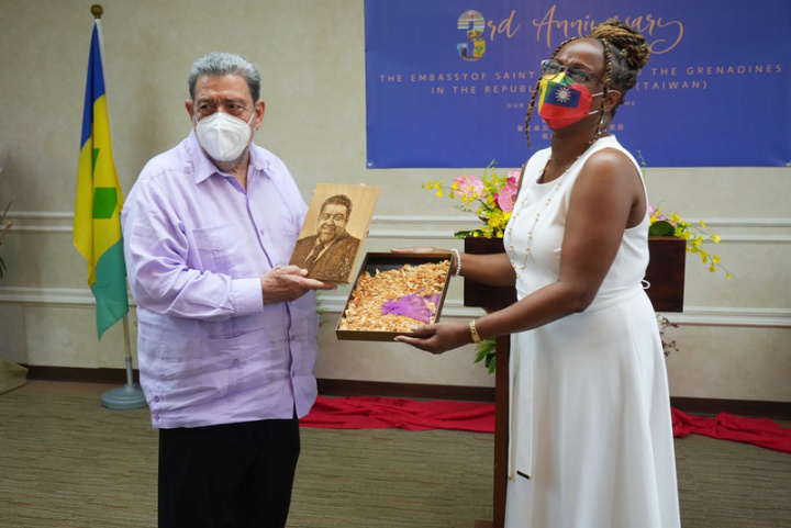 聖文森及格瑞那丁駐台使館9日舉辦設立3週年慶祝會聖國駐台大使柏安卓（Andrea Bowman）（右）特別代表致贈聖國總理龔薩福（左）一幅他的肖像藝術品作為慶生禮物。