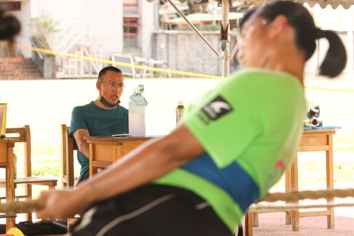 拔河代表隊總教練郭昇（左）坐在景美女中訓練場邊，宏亮的鞭策傳入選手耳裡，激勵選手拼命操練。