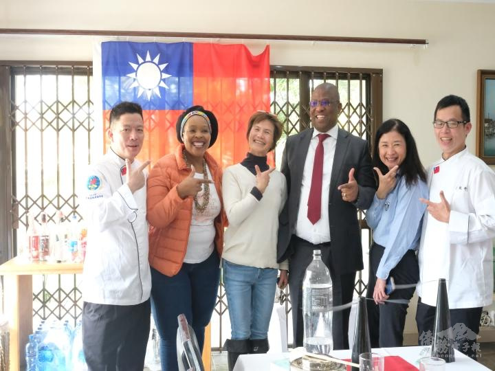 國旗前合影(左起: 葉步欽、Syia 、李素珍、Oscar Mabuyane、李綺霞、蔡敬修)