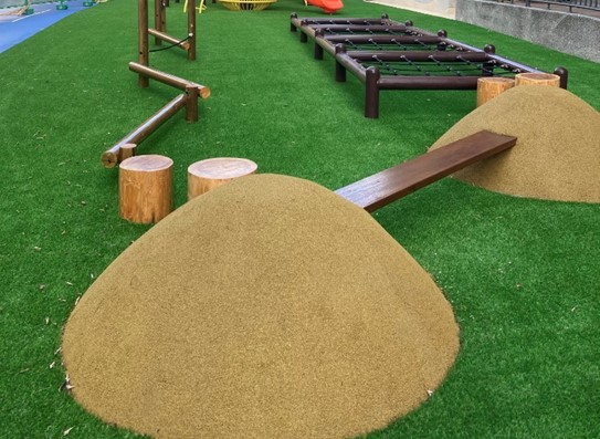 新北市積穗國民小學附設幼兒園的曬穀場意象攀爬平衡區，結合木頭、木材等自然材質做