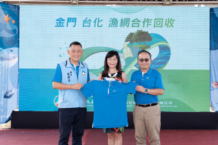 2022金門縣國家海洋日活動延至17日在新湖漁港登場，在海保署副署長宋欣真（中）見證下，金門縣長楊鎮浯（左）並與台化資深副總經理蘇俊雄（右）簽署合作意向書，共同展示由廢漁網再製而成的環保機能服飾。（金門縣政府提供）