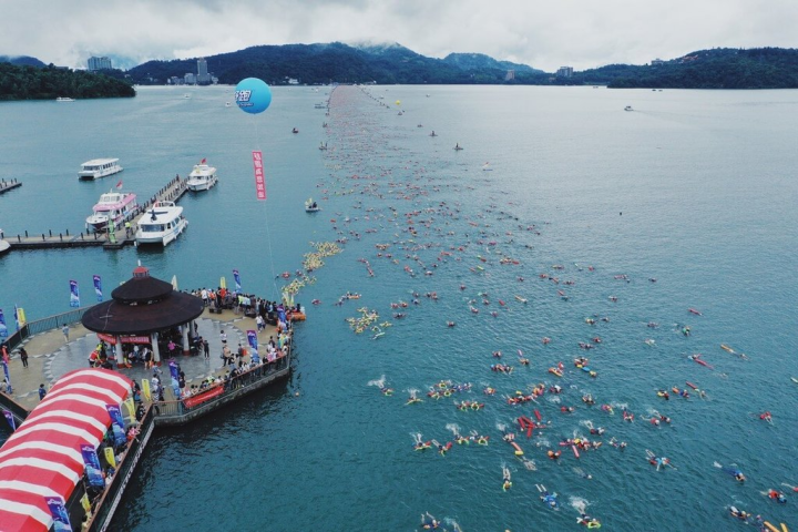 南投日月潭萬人泳渡活動4日登場，1萬8000多名泳者下水挑戰泳渡日月潭，場面壯觀。（南投縣政府提供）