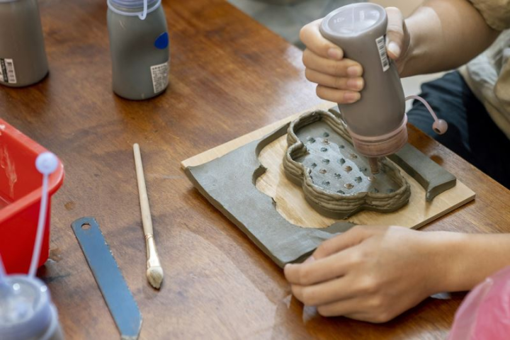 民眾體驗用陶廢漿料擠擠畫畫,透過壓瓶身讓泥條建構出造型