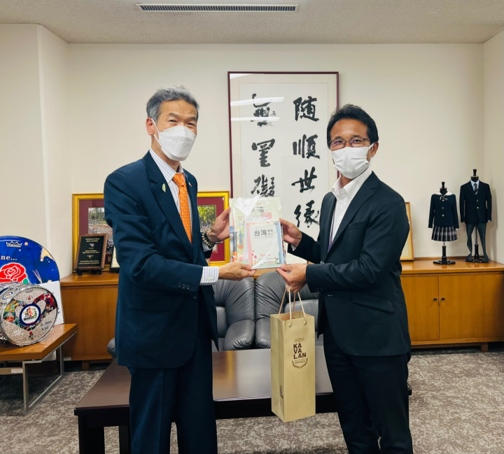 駐大阪辦事處向明德處長(左)將台灣觀光協會為每一位團員準備的紀念品交予京都橘高校安田文彥校長