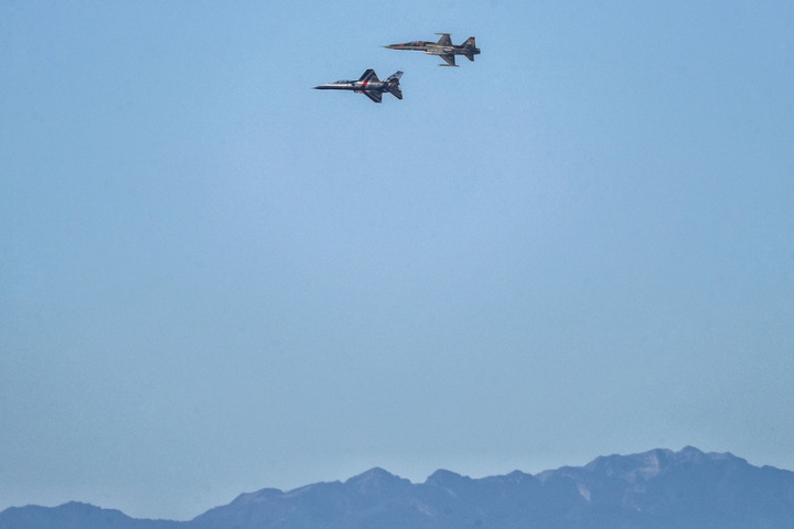 雙十國慶將至，國軍27日上午進行空中操演，勇鷹高教機（左）、F-5戰機（右）飛越台北上空。