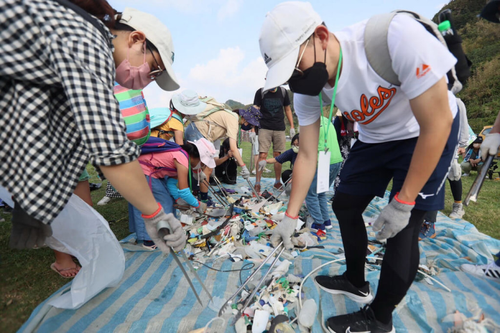 新北市政府觀光旅遊局與深澳鐵道自行車營運公司9日在瑞芳區深澳海邊舉辦淨灘活動，民眾在海洋科技博物館專業的淨灘講師及志工帶領下進行分類，共清出150公斤人為垃圾，以實際行動守護深澳段海岸風貌及珍貴海洋資源。（新北市府觀光旅遊局提供）