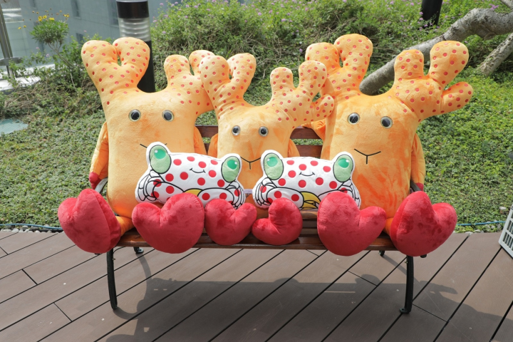 海生館自行設計開發的鹿角珊瑚絨毛娃娃，頭上紅色的點為共生藻，手上拿的是與鹿角珊瑚共生的共生蟹，兼具教育意義與趣味性。