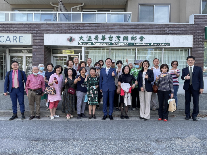 委員長童振源(第1排右5)在處長劉立欣(第1排右4)、組長陳碧蓮及秘書黃慶育陪同下，拜會大溫哥華臺灣同鄉會，與會長巴如玉(第1排右3)及該會理事幹部在會所前合影