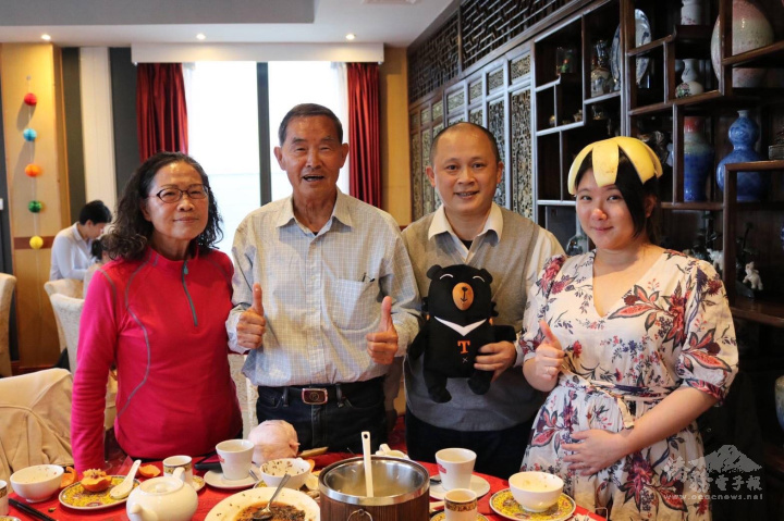 Dr. Cheng wearing a "pomelo hat" and taking a photo with guests from Taiwan. Wearing a pomelo hat is one of the fun traditions in the Moon Festival celebration.