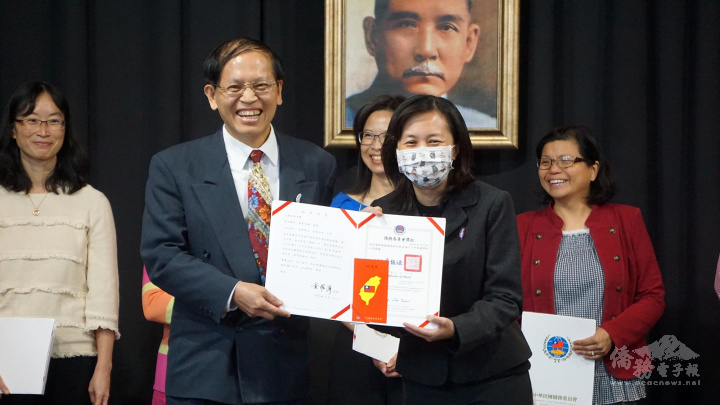 維華中文學校校長林宏圖(左)服務滿二十年﹐獲得僑委會頒發的銀質獎章﹑證書及獎金