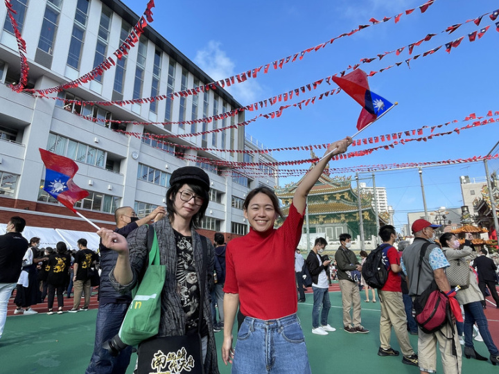 日本橫濱僑界舉辦雙十國慶活動，橫濱中華學校及周 邊的中華街張燈結彩。旅居橫濱的台僑吳小姐（右） 與日籍男性友人前來，她看到國旗喊「很激動、很感 動。」