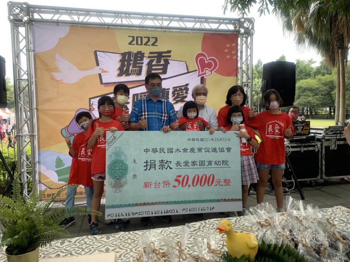 中華民國水禽產業促進發展協會15日在雲林古坑綠色隧道舉辦公益促銷活動，協會理事長吳祥斌（左4）並將活動所得盈餘新台幣5萬元全數捐助長愛家園育幼院。