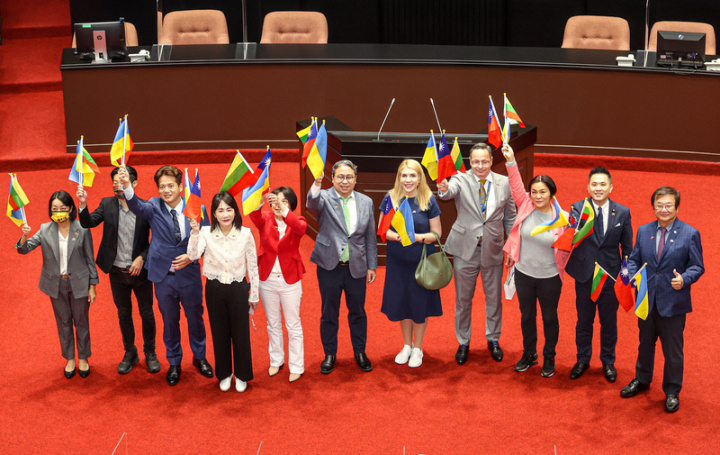 立陶宛歐洲事務委會副主席帕季格（Zygimantas  Pavilionis）（右4）、烏克蘭國會議員盧狄克（Kira  Rudik）（右5）25日在民進黨立委黃世杰（右6）等 多名立委陪伴下參訪立法院，眾人在議場內揮舞國旗 並合影。