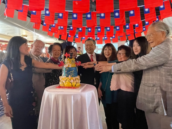 英國僑界8日舉行國慶，跨世代僑民共享特別製作的國慶主題蛋糕。駐英國代表謝武樵（右5）期勉眾人時刻不忘台灣，主辦活動的輔仁大學英國校友會會長黃瑋苑（左1）稱任何新故鄉都比不上台灣。