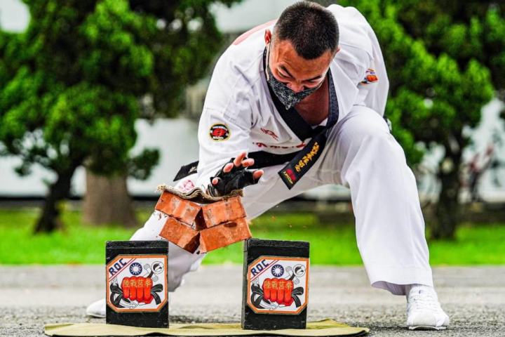 莒拳隊員以掌根功力擊破兩塊紅磚。（莒拳隊提供）